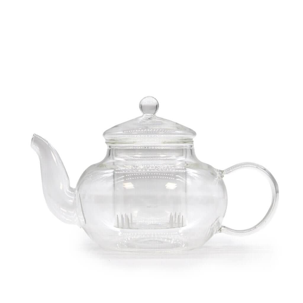A clear glass teapot with a rounded body, a spout on the left, a curved handle on the right, and a lid with a round knob on top.