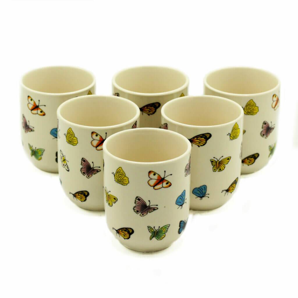 Six white ceramic cups are arranged in two rows, each decorated with colorful butterfly illustrations.