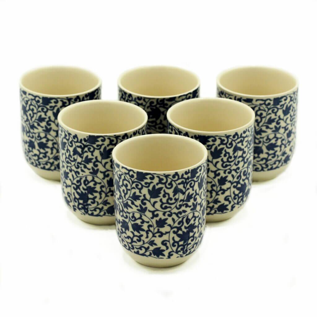 Six ceramic cups with blue and white intricate floral patterns are arranged in two rows on a plain white background.