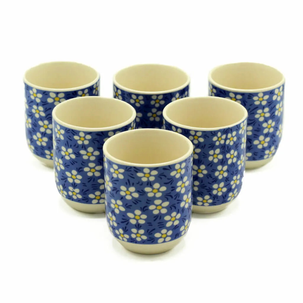 Six ceramic cups with a blue background and white floral pattern arranged in two rows on a white surface.