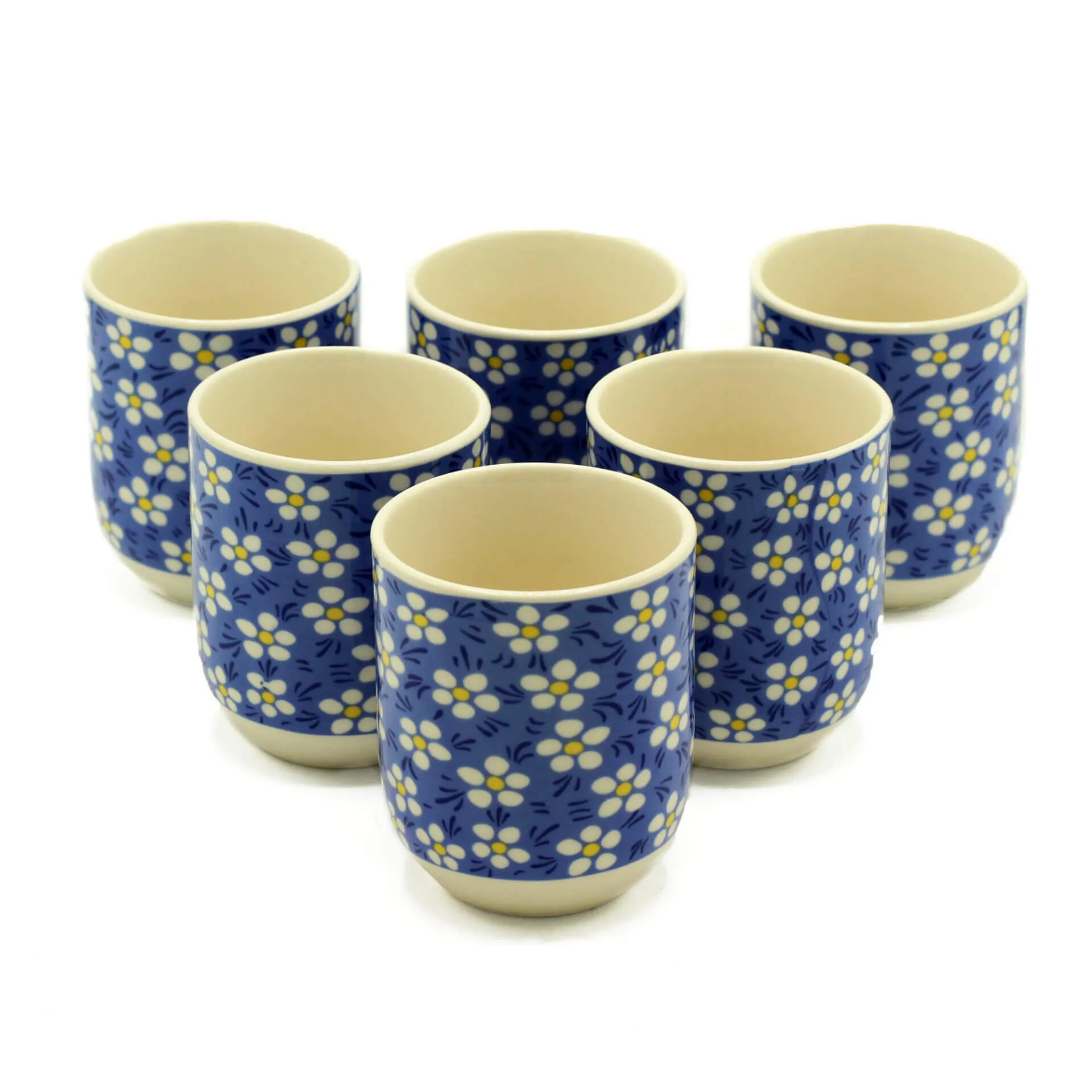 Six ceramic cups with a blue background and white floral pattern arranged in two rows on a white surface.