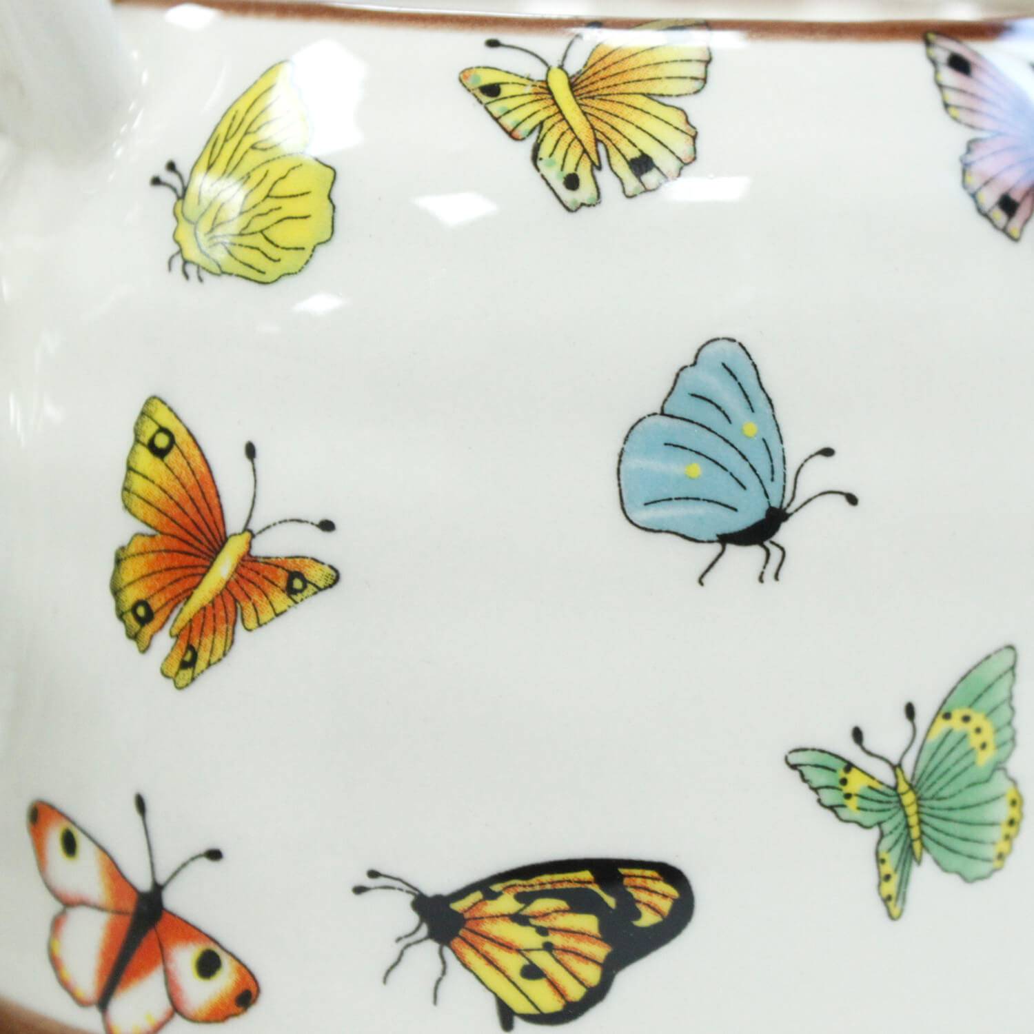 A white ceramic surface with colorful butterfly illustrations, including yellow, orange, blue, green, and multicolored butterflies.