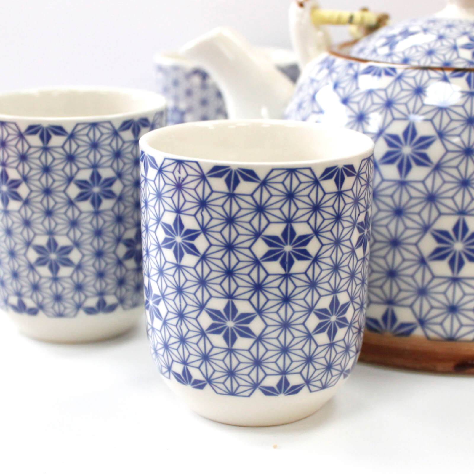 Two ceramic cups and a teapot with blue geometric patterns on a white background.