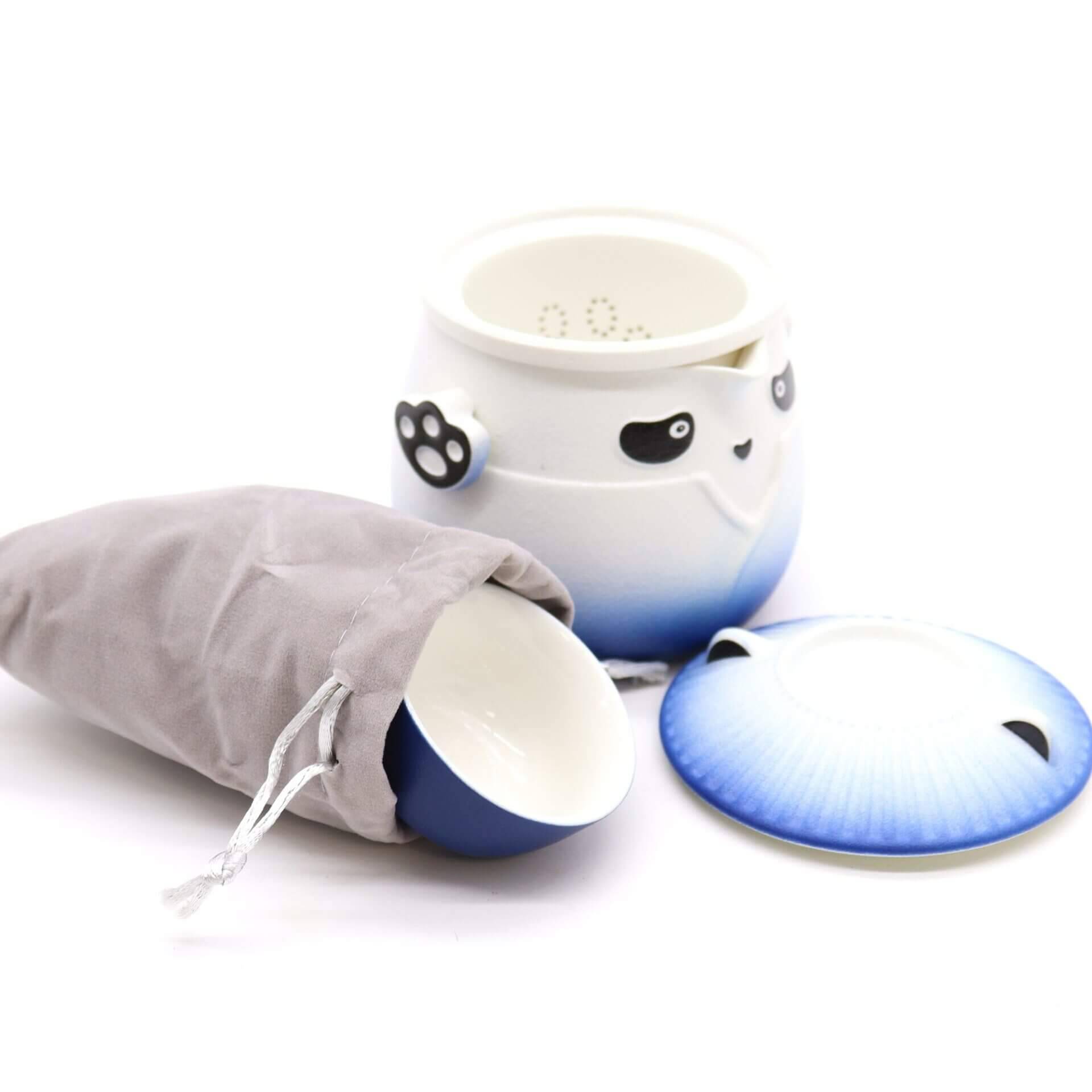 A ceramic tea cup set with a panda design, including a cup, a lid, a blue gradient saucer, and a gray drawstring pouch, displayed on a white background.