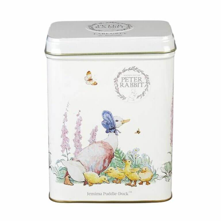 The Beatrix Potter - 40 Teabag Tin features illustrations of Jemima Puddle-Duck, ducklings, flowers, and a butterfly on a white background under "Peter Rabbit" branding. It's perfect for storing your favorite Earl Grey blend.