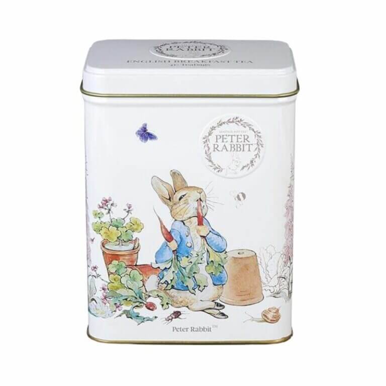 White metal tin with Beatrix Potter's illustration of Peter Rabbit in a garden holding a carrot amid lush plants and a flower pot. Contains 40 English Breakfast teabags.
