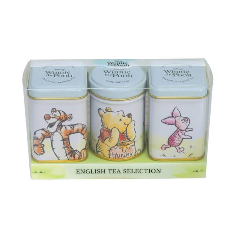 The Winnie The Pooh - Triple Mini Tin Gift Pack features charming designs of Tigger, Winnie the Pooh, and Piglet, labeled "English Tea Selection," beautifully arranged in a transparent gift box.